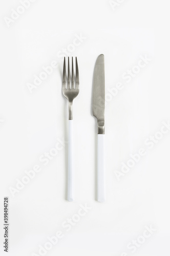 White silver or steel cutlery view from above on a white background. Top view..Knife and fork for a festive table for a wedding, birthday or party.