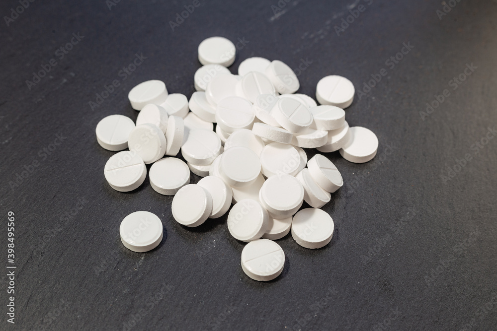 White pills, drugs on grey background. Prevention of coronavirus. Web banner on site with empty space for text on the left side. Isolated. Medical preparations close up White pills, drugs on grey background. Prevention of coronavirus. Web banner on site with empty space for text on the left side. Isolated. Medical preparations close up