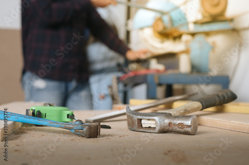 Carpenter working with equipment on wooden table in carpentry shop. woman works in a carpentry shop.