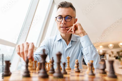 Confident focused business man playing chess