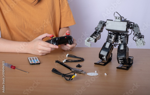 women control adjusts the robot model, girl in a robotics laboratory
