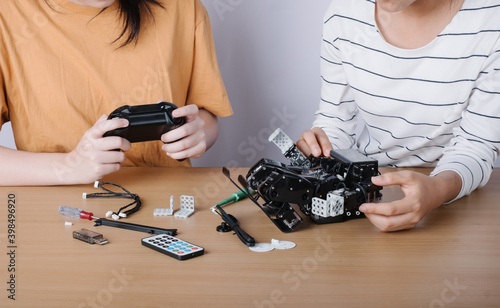 women control adjusts the robot model, girl in a robotics laboratory