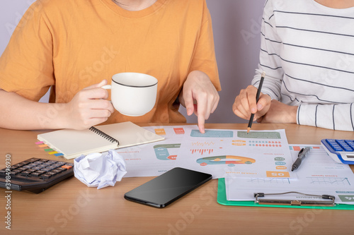Close up accountant auditing accounting reports, profit and loss data, analytical graph marketing from the file folder on the table at home.