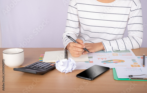 Close up accountant auditing accounting reports, profit and loss data, analytical graph marketing from the file folder on the table at home.