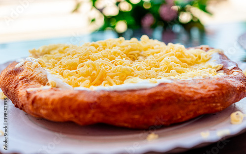 The famous, old Hungarian food called Lángos. Deep fried flatbread usually with sour cream, cheese, and garlic. photo