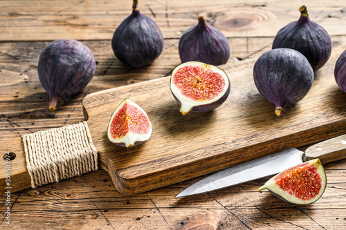 Ripe purple figs on a chopping Board. Wooden background. Top view