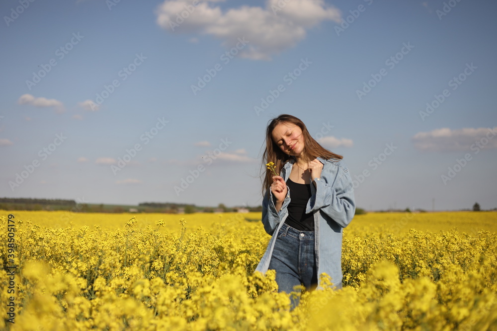 young beautiful woman in a field with yellow blooming rapeseed. girl in yellow floral field, rapeseed plantation, summer vacation concept young beautiful woman in a field with yellow blooming rapeseed. girl in yellow floral field, rapeseed plantation, summer vacation concept