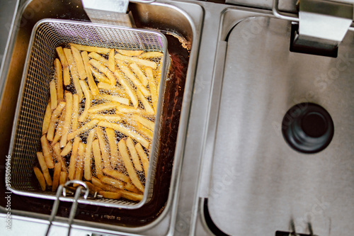 Top view of fries in deep fryer. Restaurant meal preparation, side dish