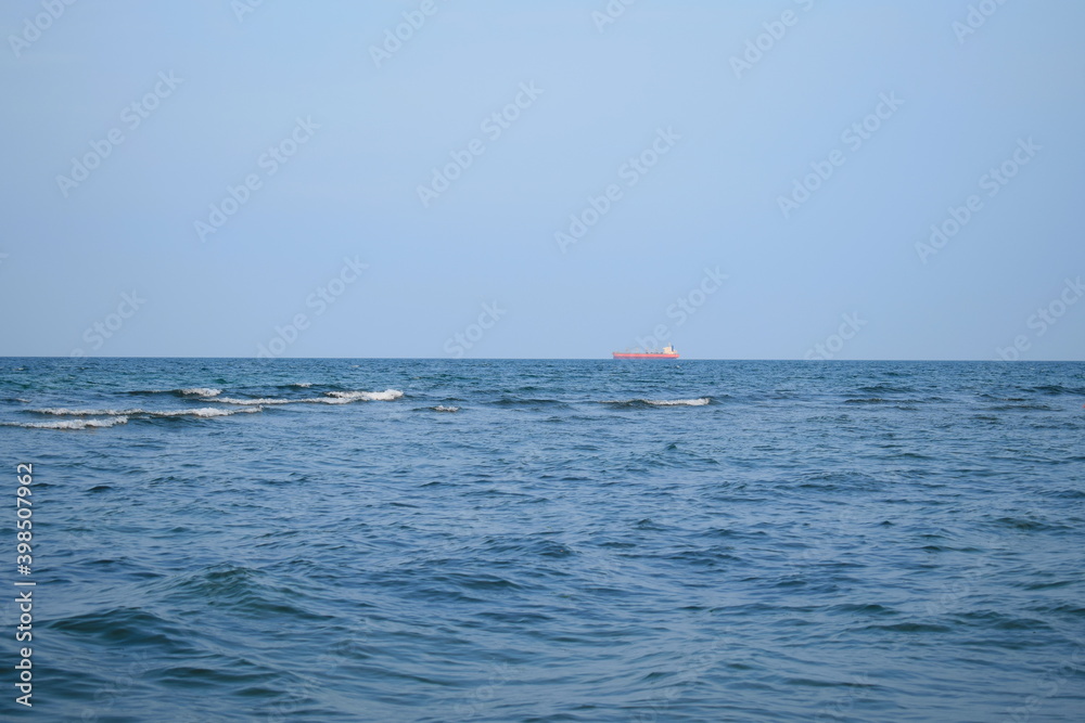 Sea view with cargo ships floating in the distance. Sea view with cargo ships floating in the distance.