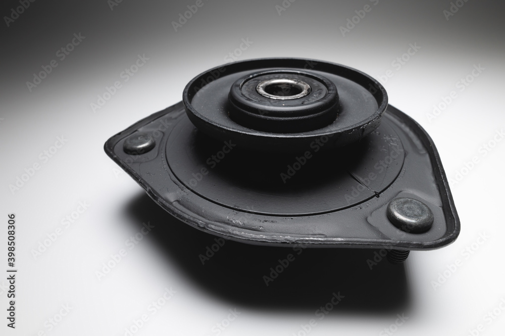 Support bearing of the front suspension in the silent block. New undercarriage part on a gray background Support bearing of the front suspension in the silent block. New undercarriage part on a gray background