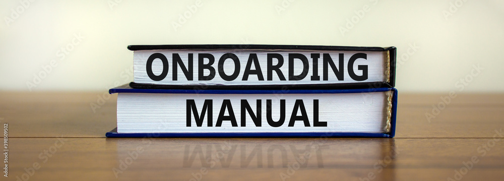 Fototapeta premium Onboarding manual symbol. Books with words 'onboarding manual' on beautiful wooden table. White background. Business and onboarding manual concept. Copy space.