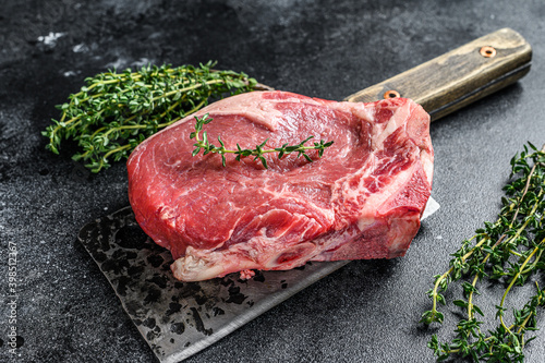 Raw beef striploin on the bone meat steak. Black ground. Top view