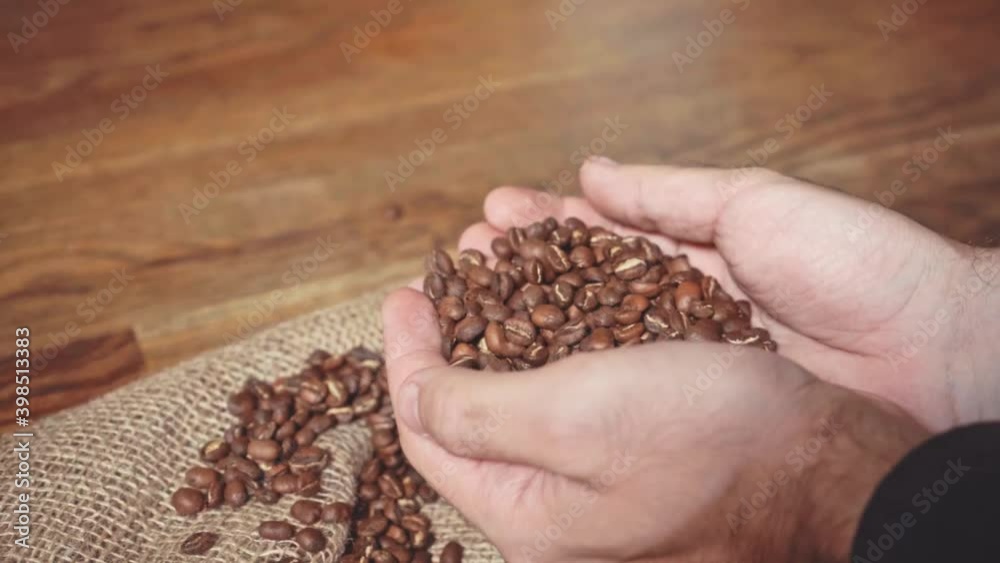 slow motion of male hands touching roasted coffee beans slow motion of male hands touching roasted coffee beans