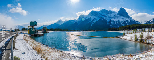 Rundle Forebay Reservoir in winter sunny day morning. Clear blue sky, snow capped Mount Lawrence Grassi mountain range in background. Canmore, AB, Canada. photo