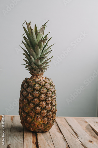 Big ripe ananas on wooden table on blue background