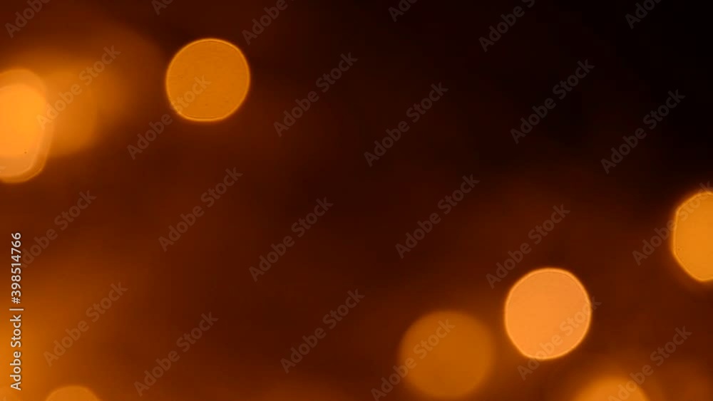 Abstract golden bokeh lights glowing on dark background Abstract golden bokeh lights glowing on dark background