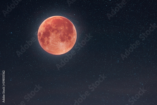 Beautiful full bloody moon in the starry sky. Astronomical background.