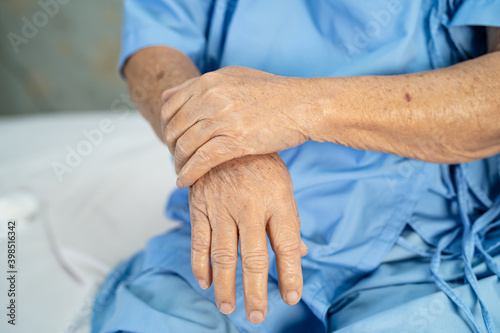 Asian senior or elderly old lady woman patient feel pain her hand on bed in nursing hospital ward, healthy strong medical concept.