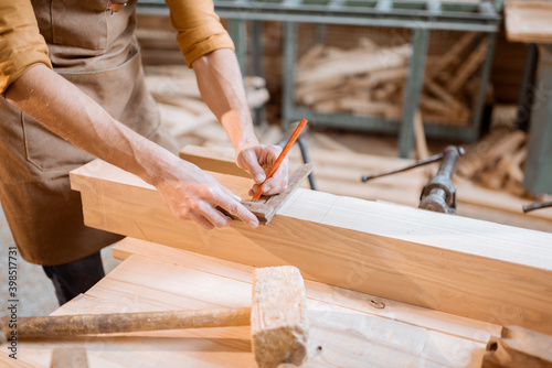 Carpenter working with a wood indoors