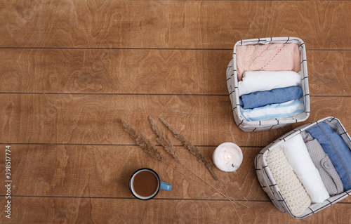 A group of organic cotton clothing laid out on a wooden background is ready to be folded into white baskets.The concept of closet organization.using the komari method. photo