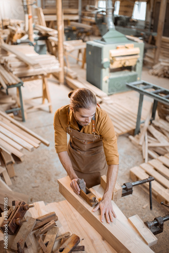 Carpenter working with a wood in the workshop