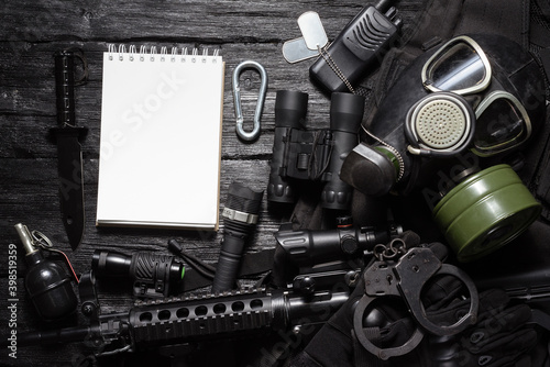 Military equipment list template concept. Airsoft equipment on the black table background.