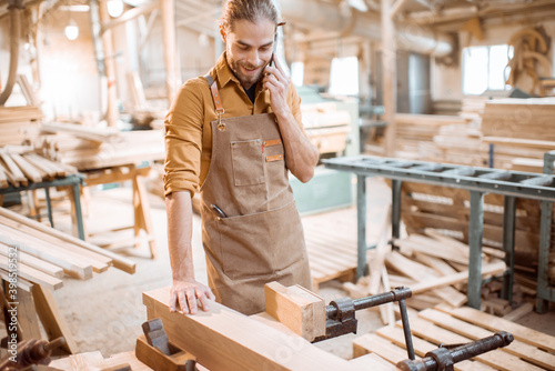 Carpenter with phone in the workshop