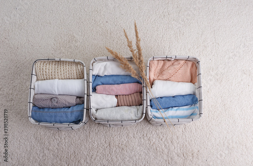 A group of clothes made of organic cotton, neatly folded in baskets for storing underwear .The concept of closet organization. photo