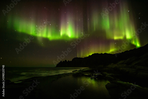Northern lights reflected on the sea on a cold night in norway © criskorah