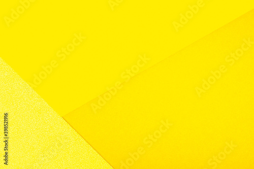 Abstract paper geometric background in shades of yellow. Color of the year 2021 illuminating