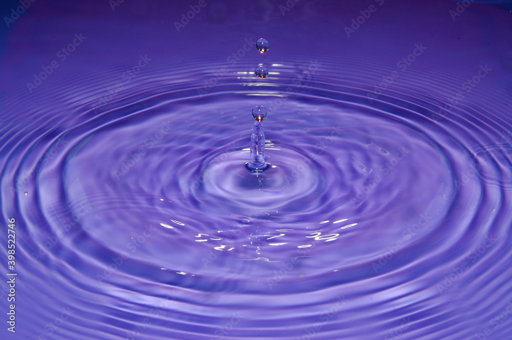 Water droplet impact frozen splash with droplets and concentric rings Water droplet impact frozen splash with droplets and concentric rings