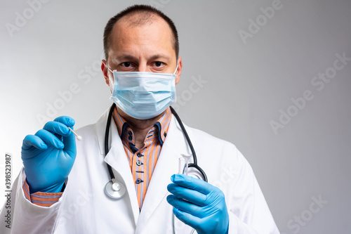 Medical healthcare holding COVID-19 , Coronavirus swab collection kit, wearing PPE protective suit mask gloves, test tube for taking OP NP patient specimen sample,PCR DNA testing protocol process © Nenad