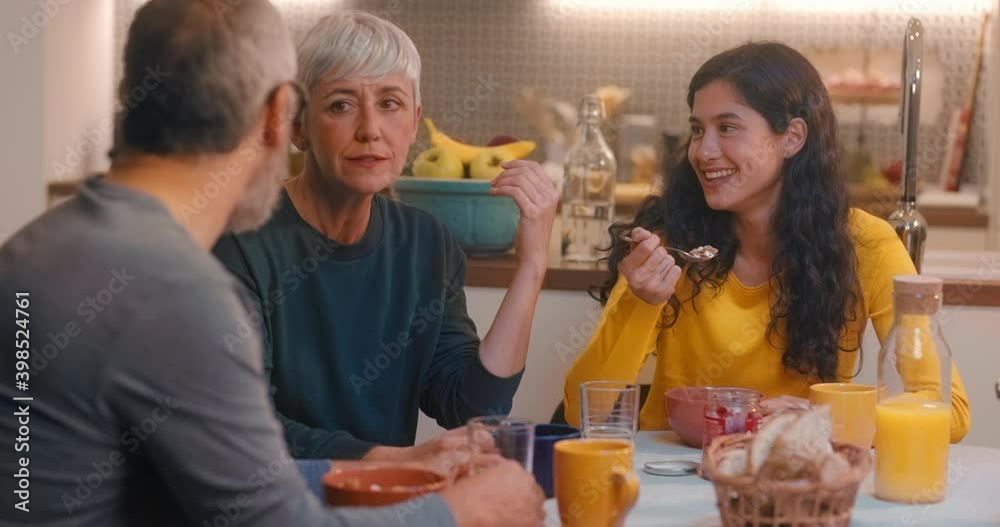 Happy family eating and talking during breakfast Happy family eating and talking during breakfast