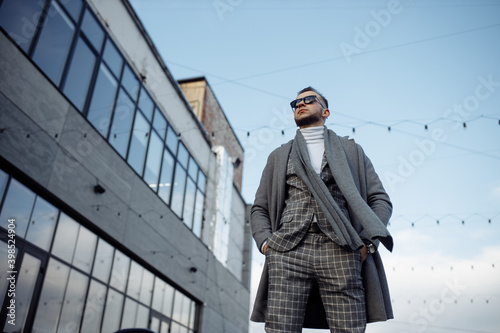 Wallpaper Mural Low angle view photo of young man in suit grey coat scarf walking in the city streets Torontodigital.ca