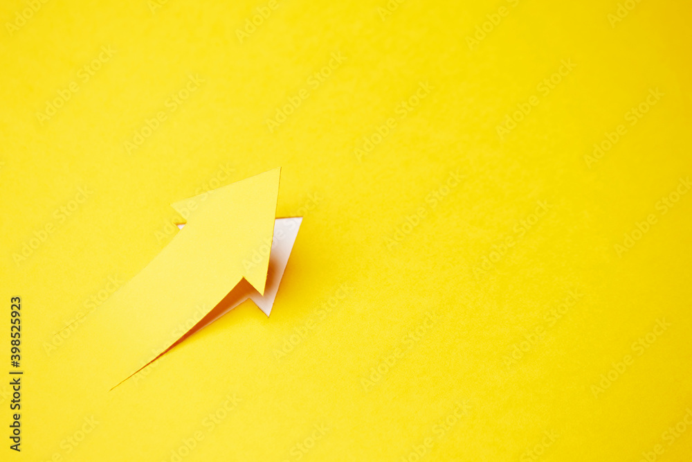 Right-up arrow cutted from solid sheet of yellow paper and curved up of one side with white paper underlay showing growth of stock market or up direction - obrazy, fototapety, plakaty 