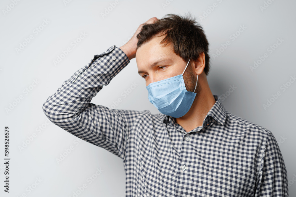 Man wearing hygienic mask against grey background Man wearing hygienic mask against grey background