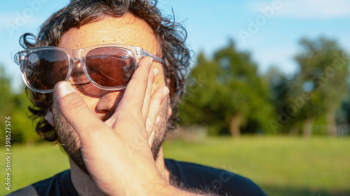 CLOSE UP: Man's sunglasses fly off face after getting slapped by unknown person. photo