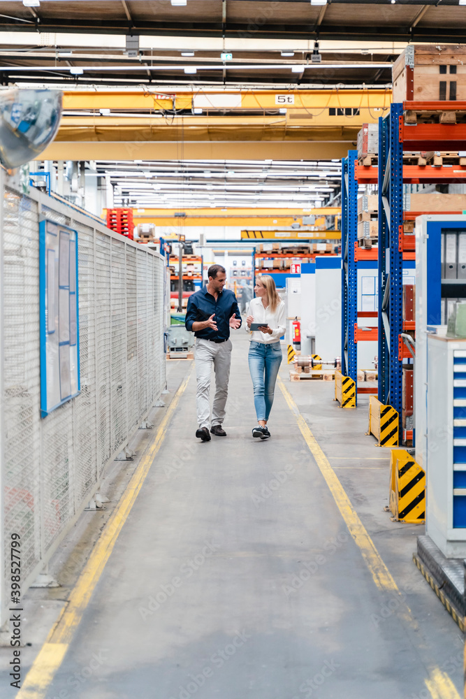 custom made wallpaper toronto digitalBusinesswoman discussing with male colleague while walking in factory