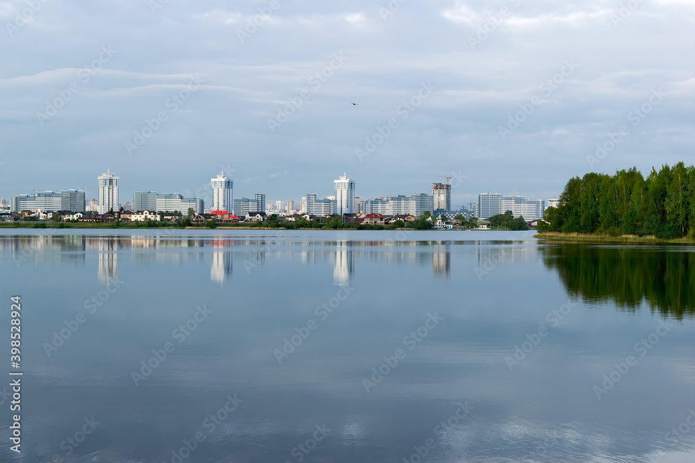 city with tall houses is reflected in the lake
