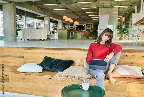 Woman using digital tablet while sitting at modern office photo