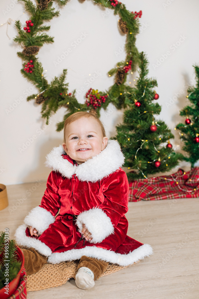 Little cute boy dressed as Santa near little Christmas trees. Christmas mood Little cute boy dressed as Santa near little Christmas trees. Christmas mood