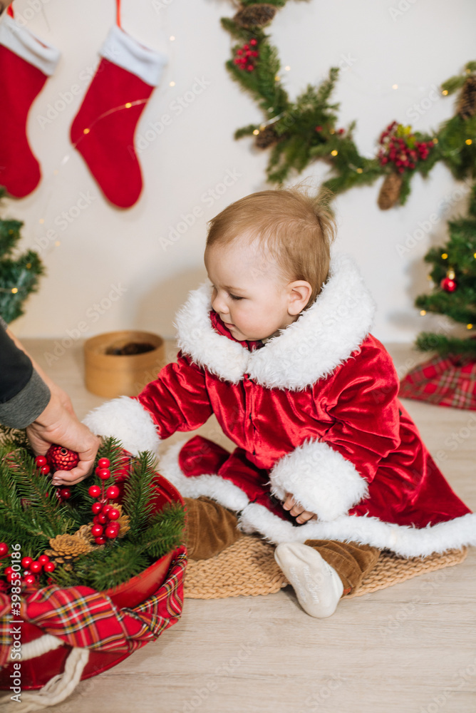 Little cute boy dressed as Santa near little Christmas trees. Christmas mood Little cute boy dressed as Santa near little Christmas trees. Christmas mood