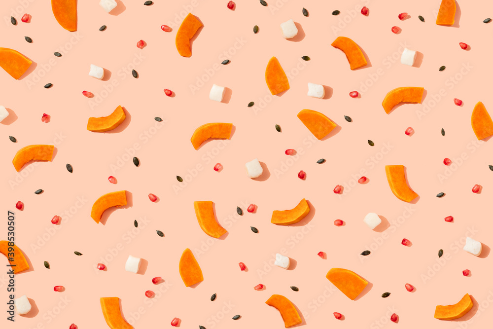 Pattern of pumpkin seeds, pomegranate seeds and pieces of cheese and pumpkin