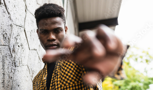 Young man stretching hand while standing by wall