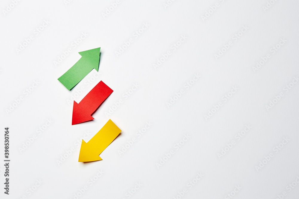 Three different direction right-up/left-down arrows, cutted from the yellow, red and green paper on the white plain paper background Three different direction right-up/left-down arrows, cutted from the yellow, red and green paper on the white plain paper background