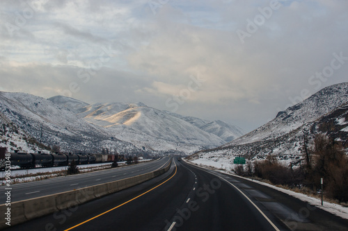 Highway in the middle of the mountains in a snowy winter. A beautiful asphalt road among the snow-covered mountains. Oregon, USA, 02-06-2019
