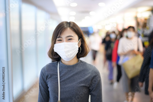 Woman wearing protective mask shopping under Covid-19 pandemic in shopping mall, social distancing protocol, New normal concept..