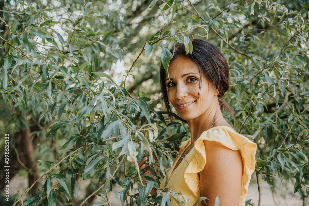 Mature woman standing under willow tree