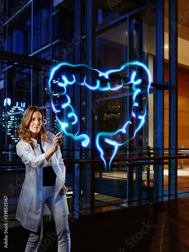 Female doctor examining large intestine with light painting at hospital