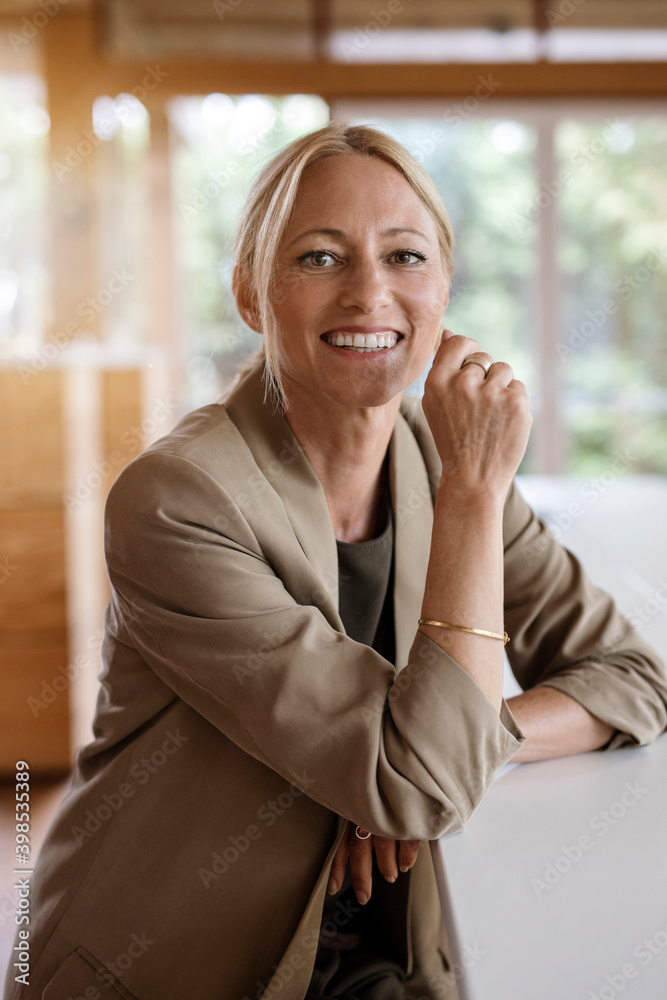 Businesswoman smiling while sitting by table at home